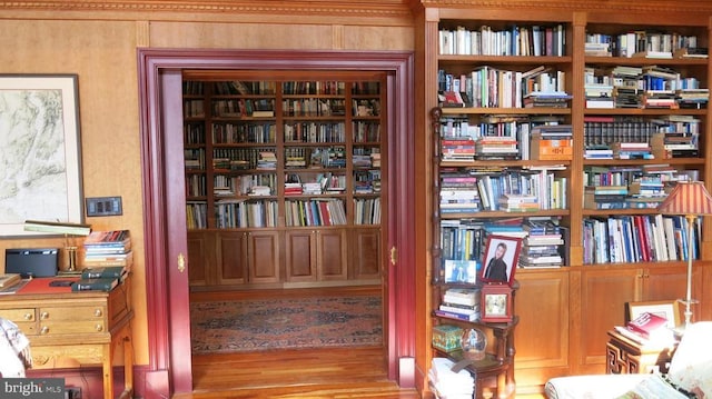  - living area featuring bookshelves and wood finished floors