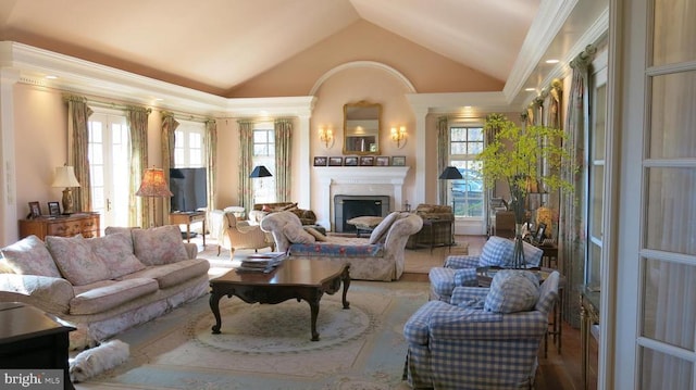  - living room with lofted ceiling, plenty of natural light, a fireplace, and ornamental molding