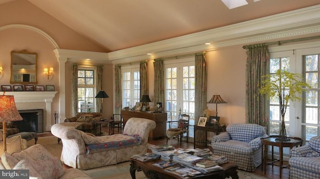  - living room featuring lofted ceiling, ornamental molding, french doors, and plenty of natural light