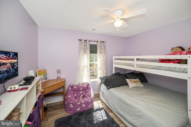 bedroom featuring wood finished floors, a ceiling fan, and baseboards