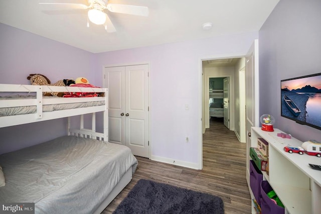 bedroom featuring baseboards, wood finished floors, a ceiling fan, attic access, and a closet