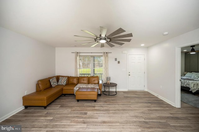 living room featuring a ceiling fan, wood finished floors, baseboards, and recessed lighting