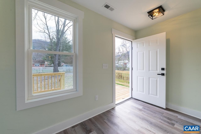 entrance foyer with visible vents, wood finished floors, and baseboards