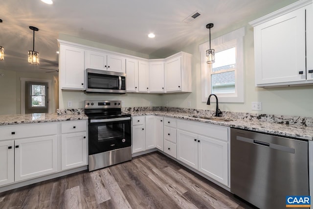kitchen featuring a sink, stainless steel appliances, white cabinetry, and a healthy amount of sunlight