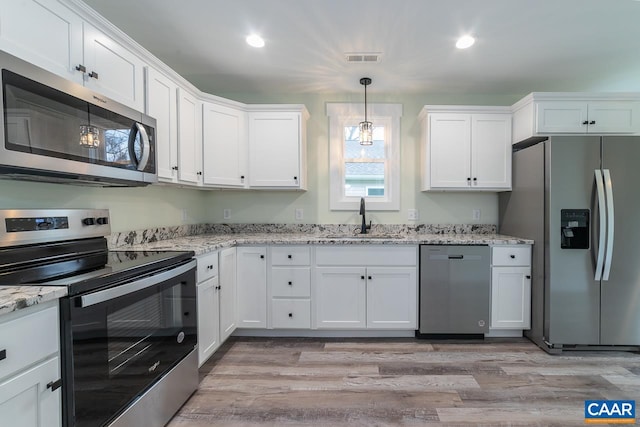 kitchen featuring a sink, white cabinetry, light wood-style floors, and appliances with stainless steel finishes