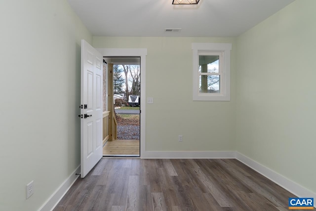 doorway with baseboards, visible vents, and wood finished floors