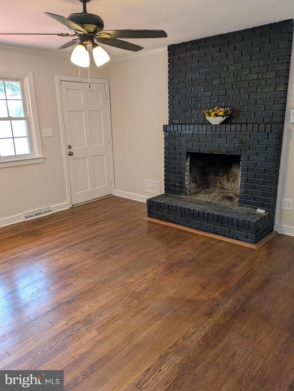 6461 Brokenburg Rd, Spotsylvania, VA 22551 - unfurnished living room featuring a ceiling fan, wood finished floors, crown molding, baseboards, and a fireplace