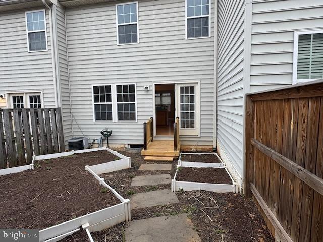 doorway to property with fence and central AC unit