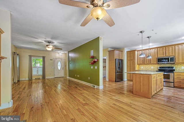 188 Byrd Point Ln, Louisa, VA 23093 - kitchen with appliances with stainless steel finishes, a ceiling fan, open floor plan, decorative backsplash, and a center island