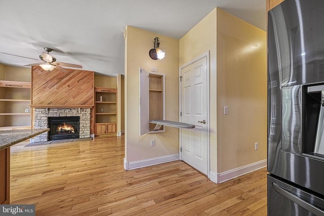 188 Byrd Point Ln, Louisa, VA 23093 - kitchen with freestanding refrigerator, a ceiling fan, light wood-style floors, and a stone fireplace