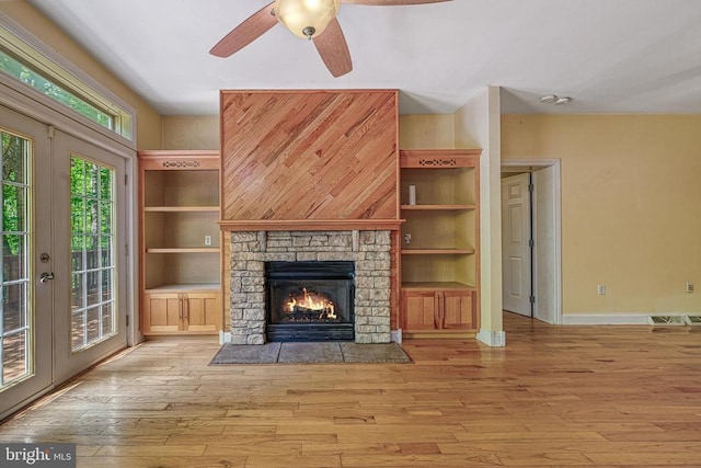 188 Byrd Point Ln, Louisa, VA 23093 - unfurnished living room with wood-type flooring, ceiling fan, a fireplace, and french doors