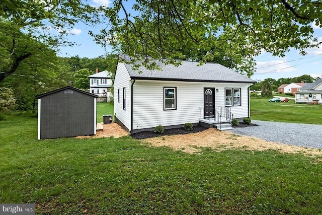 105 Cammack St, Louisa, VA 23093 - view of front of house with a storage unit, a front yard, an outbuilding, and a shingled roof