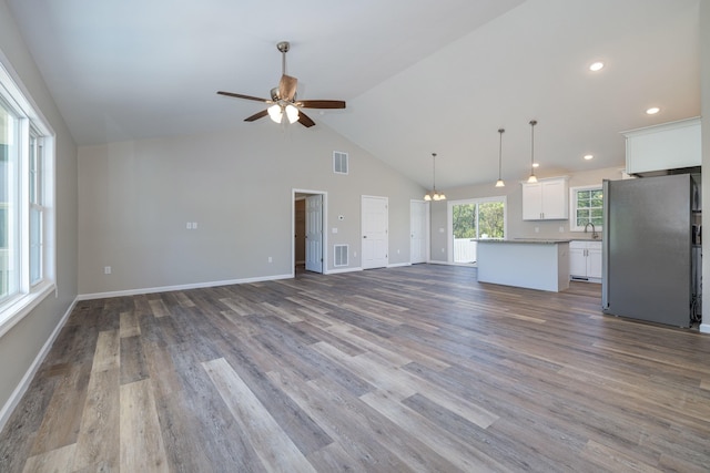 16854 E Summit Ave E, Elkton, VA 22827 - unfurnished living room with a ceiling fan, dark wood-style floors, a chandelier, high vaulted ceiling, and baseboards