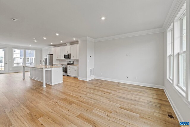 kitchen featuring crown molding, visible vents, a kitchen breakfast bar, and appliances with stainless steel finishes