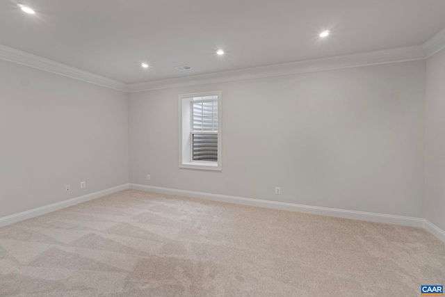 empty room with baseboards, ornamental molding, and light colored carpet