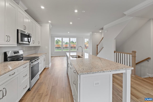 kitchen featuring recessed lighting, appliances with stainless steel finishes, ornamental molding, and a sink