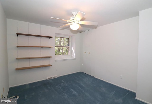  - spare room with dark colored carpet, ceiling fan, and baseboards
