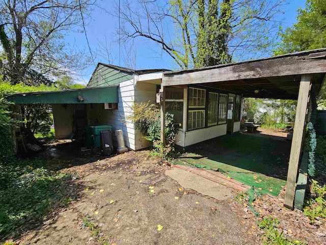 view of home's exterior featuring a sunroom and a carport