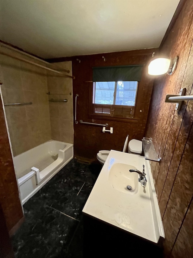 full bathroom with bathing tub / shower combination, toilet, wood walls, and vanity