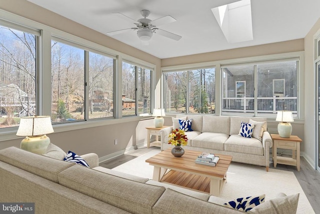 sunroom featuring baseboards, plenty of natural light, and wood finished floors