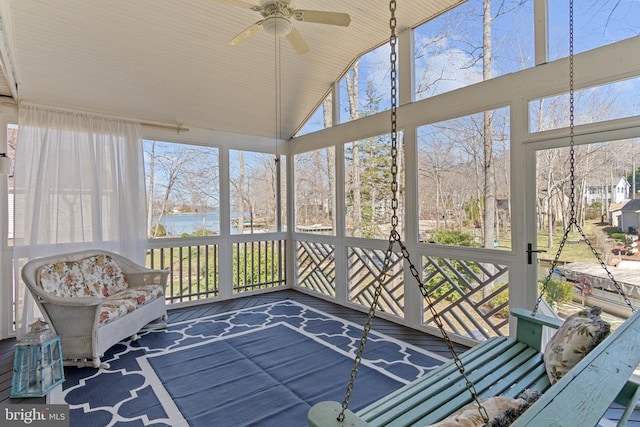 sunroom / solarium featuring ceiling fan and a water view