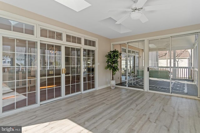 unfurnished sunroom with a skylight, ceiling fan, and french doors