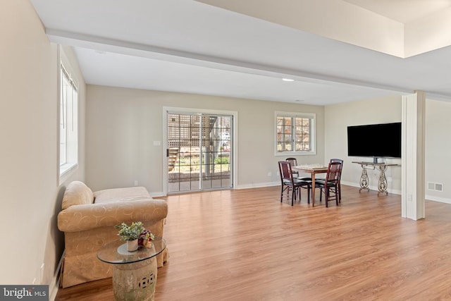 living area featuring light wood-style floors and baseboards
