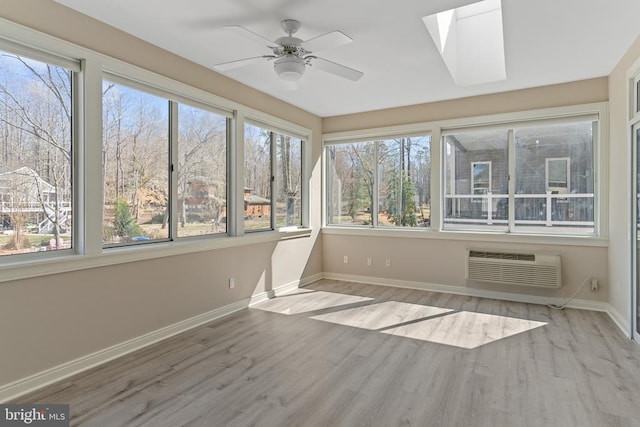 unfurnished sunroom with baseboards, healthy amount of natural light, wood finished floors, and a wall mounted AC