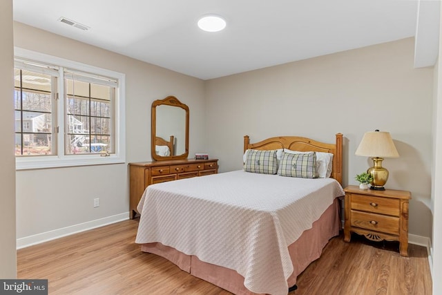 bedroom with light wood finished floors and baseboards