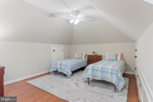 bedroom featuring wood finished floors, lofted ceiling, a ceiling fan, and baseboards