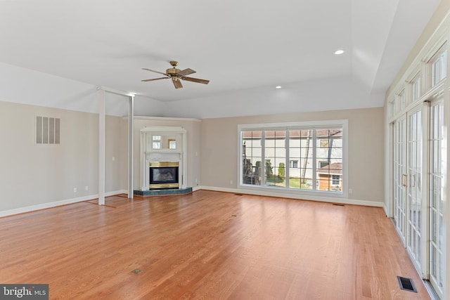 unfurnished living room with light wood-style floors, ceiling fan, baseboards, a glass covered fireplace, and recessed lighting