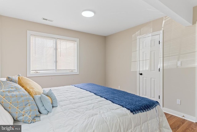 bedroom with wood finished floors and baseboards