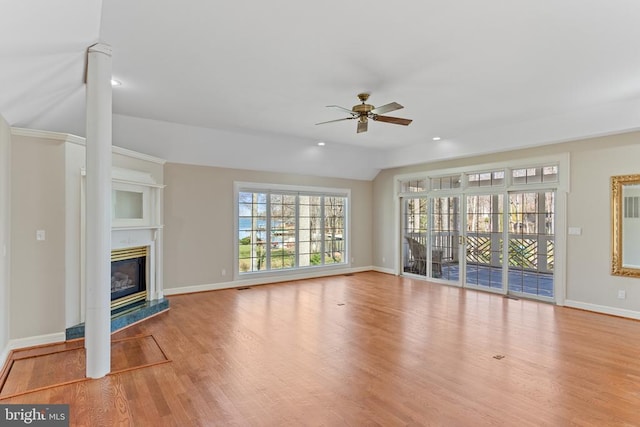unfurnished living room with ceiling fan, plenty of natural light, baseboards, wood finished floors, and recessed lighting