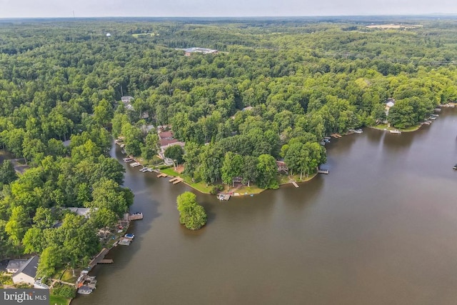 drone / aerial view of a heavily wooded area and a nearby body of water