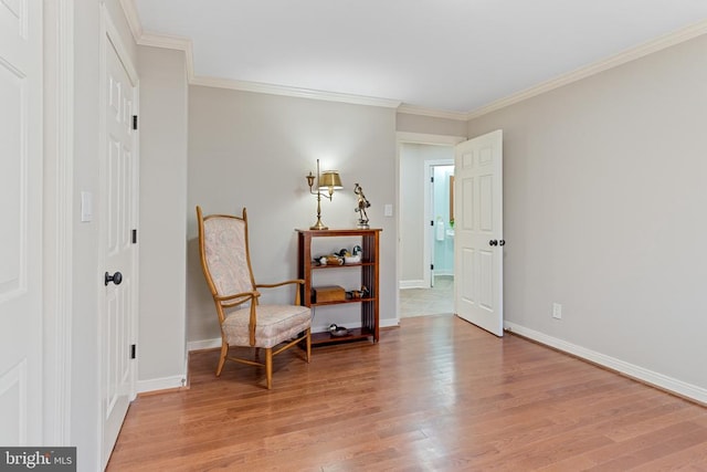 living area with light wood-style flooring, ornamental molding, and baseboards