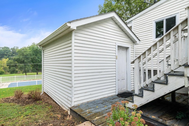 view of side of property featuring stairs, fence, and an outdoor structure