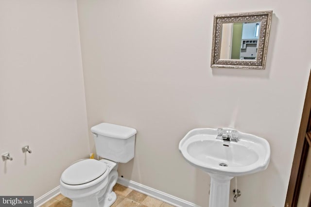 bathroom with toilet and baseboards