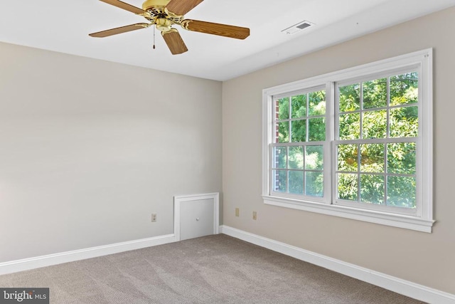 spare room featuring carpet floors, visible vents, ceiling fan, and baseboards