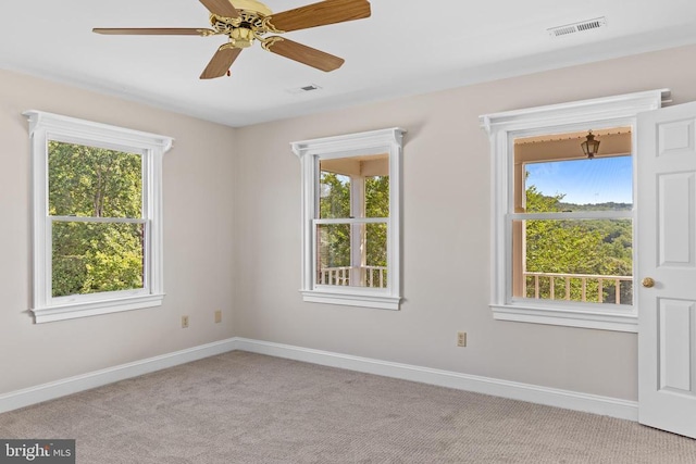 empty room with carpet, visible vents, and baseboards