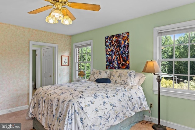 carpeted bedroom featuring wallpapered walls, baseboards, and a ceiling fan