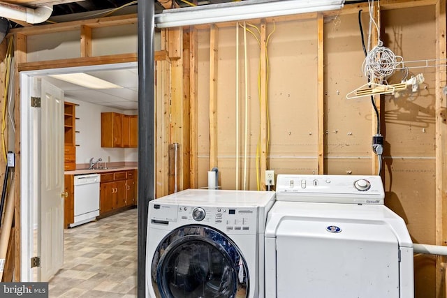 washroom with a sink, light floors, laundry area, and washer and dryer