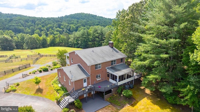 bird's eye view featuring a wooded view and a rural view