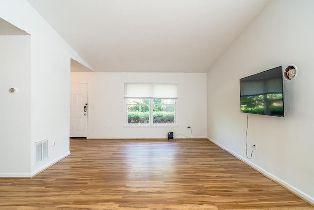 1014 Paul St, Harrisonburg, VA 22802 - unfurnished living room featuring light wood-type flooring, lofted ceiling, and baseboards