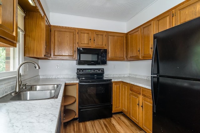 1014 Paul St, Harrisonburg, VA 22802 - kitchen featuring black appliances, a sink, light countertops, light wood-style floors, and brown cabinetry