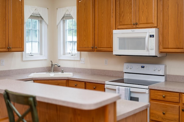 116 Buckingham Pl, Waynesboro, VA 22980 - kitchen with white appliances, a sink, light countertops, and brown cabinets