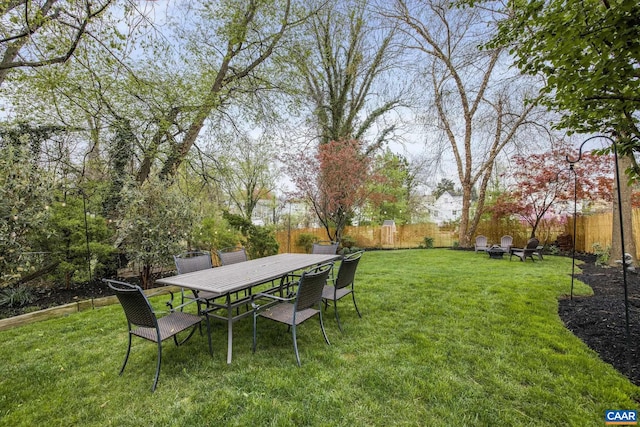 view of yard with outdoor dining space and a fenced backyard