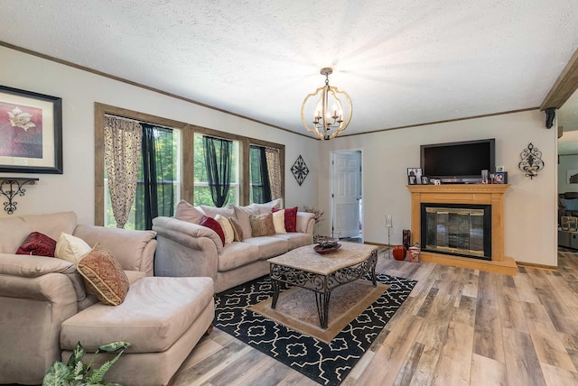 2749 Lee Hwy E, New Market, VA 22844 - living room with crown molding, a chandelier, light wood-style flooring, a textured ceiling, and a glass covered fireplace