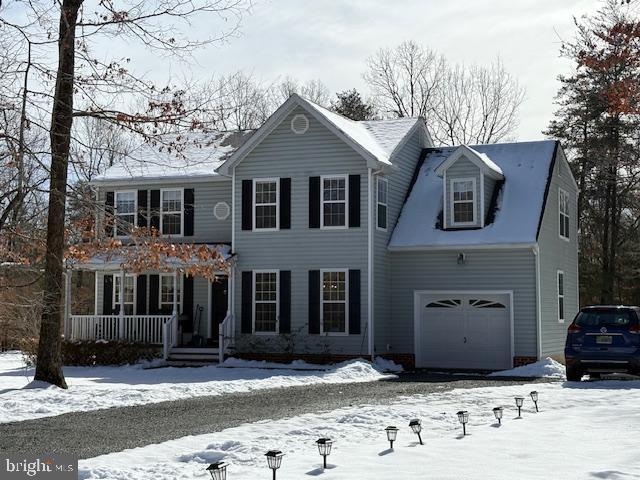 colonial home with a garage and covered porch