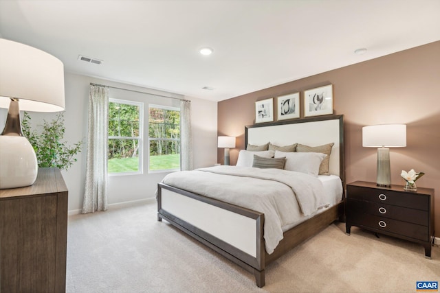 bedroom featuring light carpet, baseboards, and visible vents