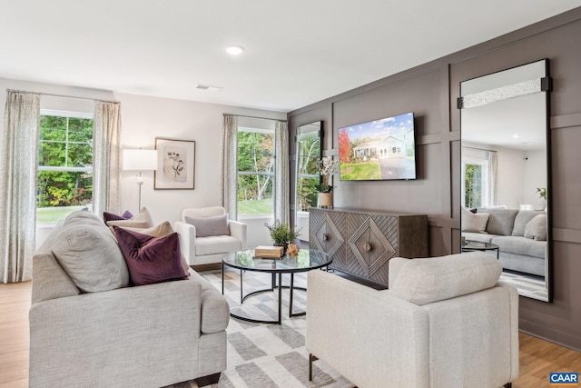 living room with light wood finished floors, visible vents, a healthy amount of sunlight, and recessed lighting